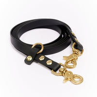 Photo - Sleek black dog leash with gold hardware for pets. Durable and elegant, designed for premium dog walking in Montreal, Canada.