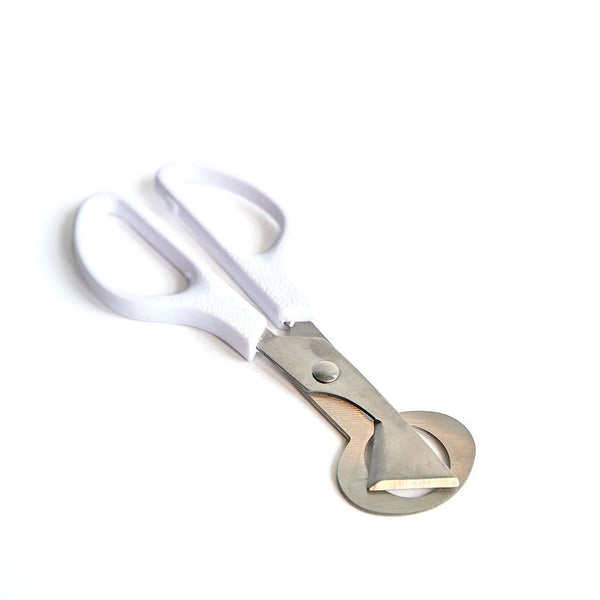Photo - Stainless steel quail egg cutting scissors with ergonomic white handles, perfect for raw dog food preparation, photographed in Montreal, Canada.